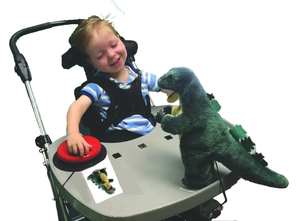 Little girl activating a toy dagon using a labelled big red assistive technology switch.