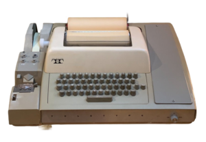 The machine shown in the document is a Teletype Model 33, manufactured by the Teletype Corporation.More specifically, the image depicts the Model 33 ASR (Automatic Send-Receive), which can be identified by the paper tape punch and reader attached to the left side of the unit.